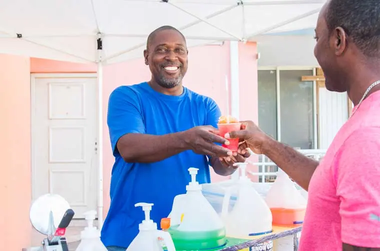 Entrepreneur financé par l'Adie servant une boisson glacée à son client