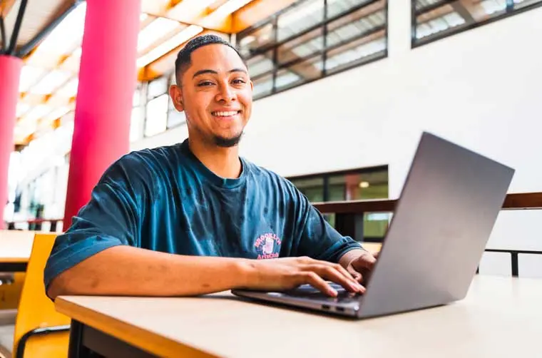 Entrepreneur financé par l'Adie écrivant sur son ordinateur portable