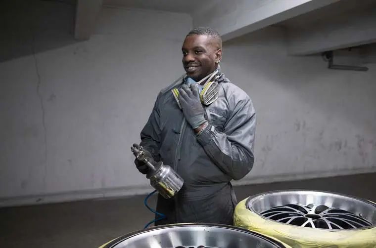 André, micro entrepreneur dans la peinture automobile tenant son matériel de travail