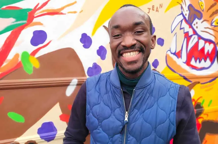 Entrepreneur financé par l'Adie devant un mur coloré peint de manière enfantine