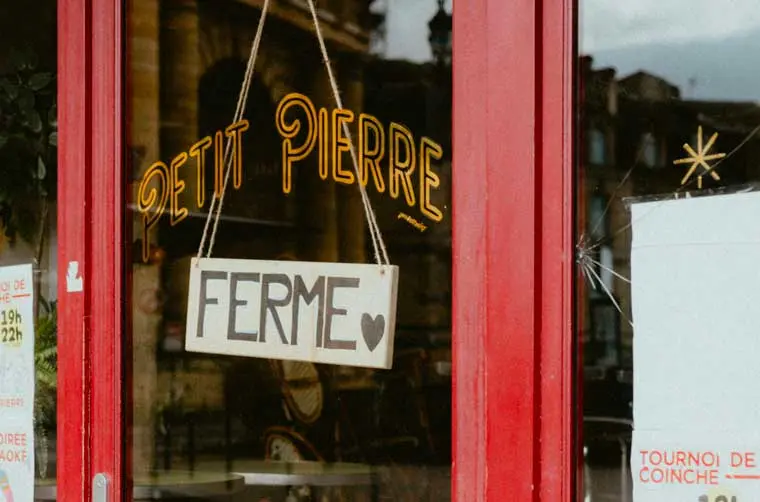 Gros plan sur la porte de la boutique "Petit Pierre", avec un écriteau indiquant "fermé"