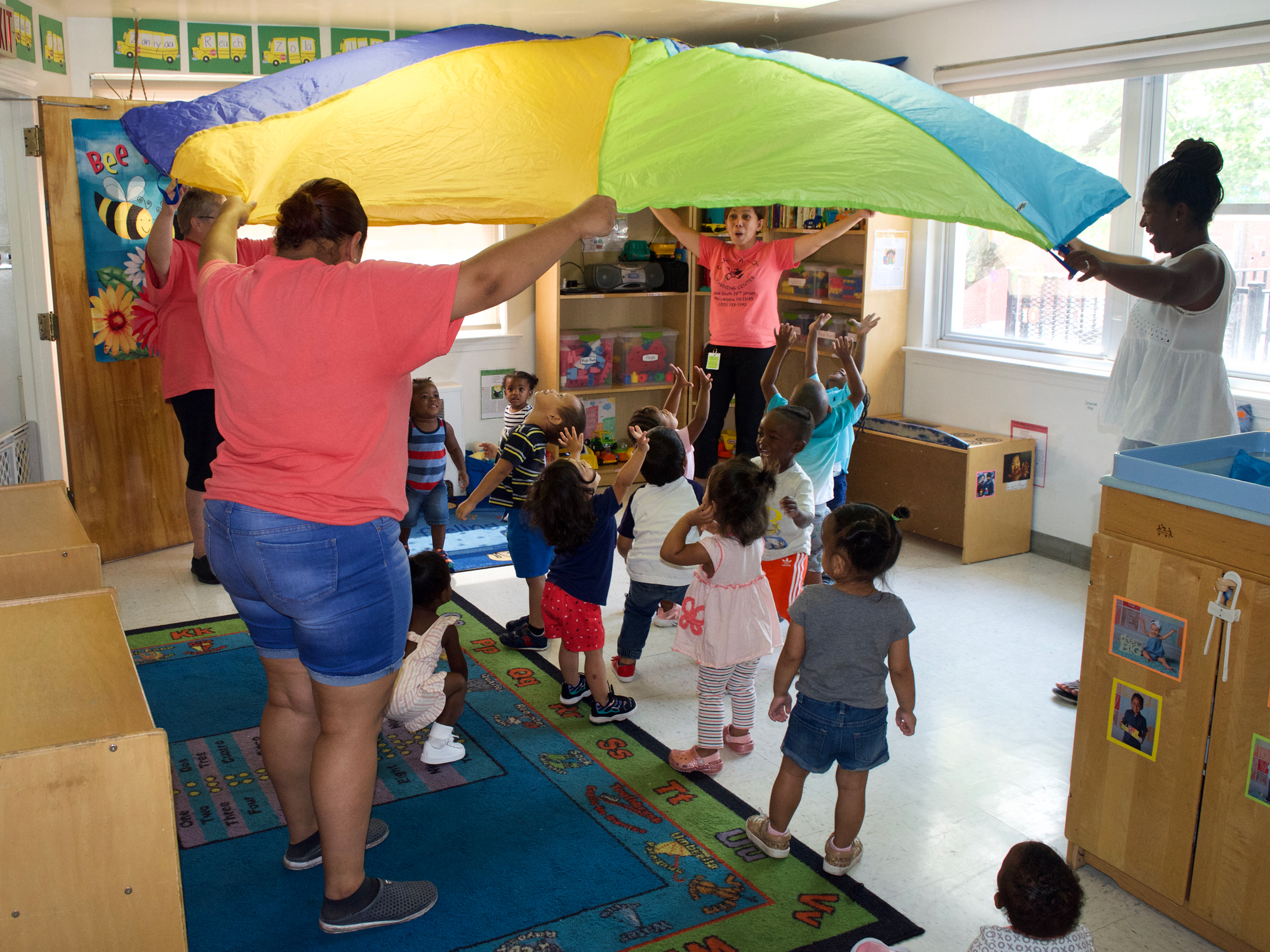 Yaribel Mercedes-Perez, front, and her fellow teachers in the toddler classroom at Philadelphia's Care-A-Lot Learning Center use activities, songs and dancing to instruct the kids. (Emily Tate / EdSurge)