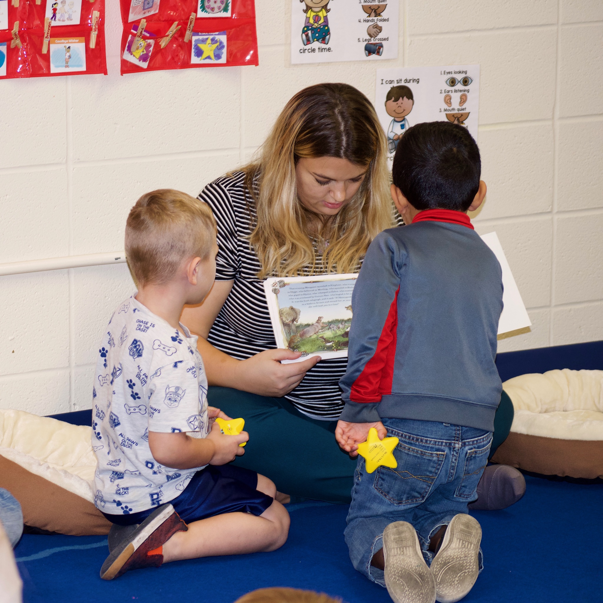 Ryder and a classmate listen as Montessa Morgan reads a book to the children in Classroom A. (Emily Tate / EdSurge)