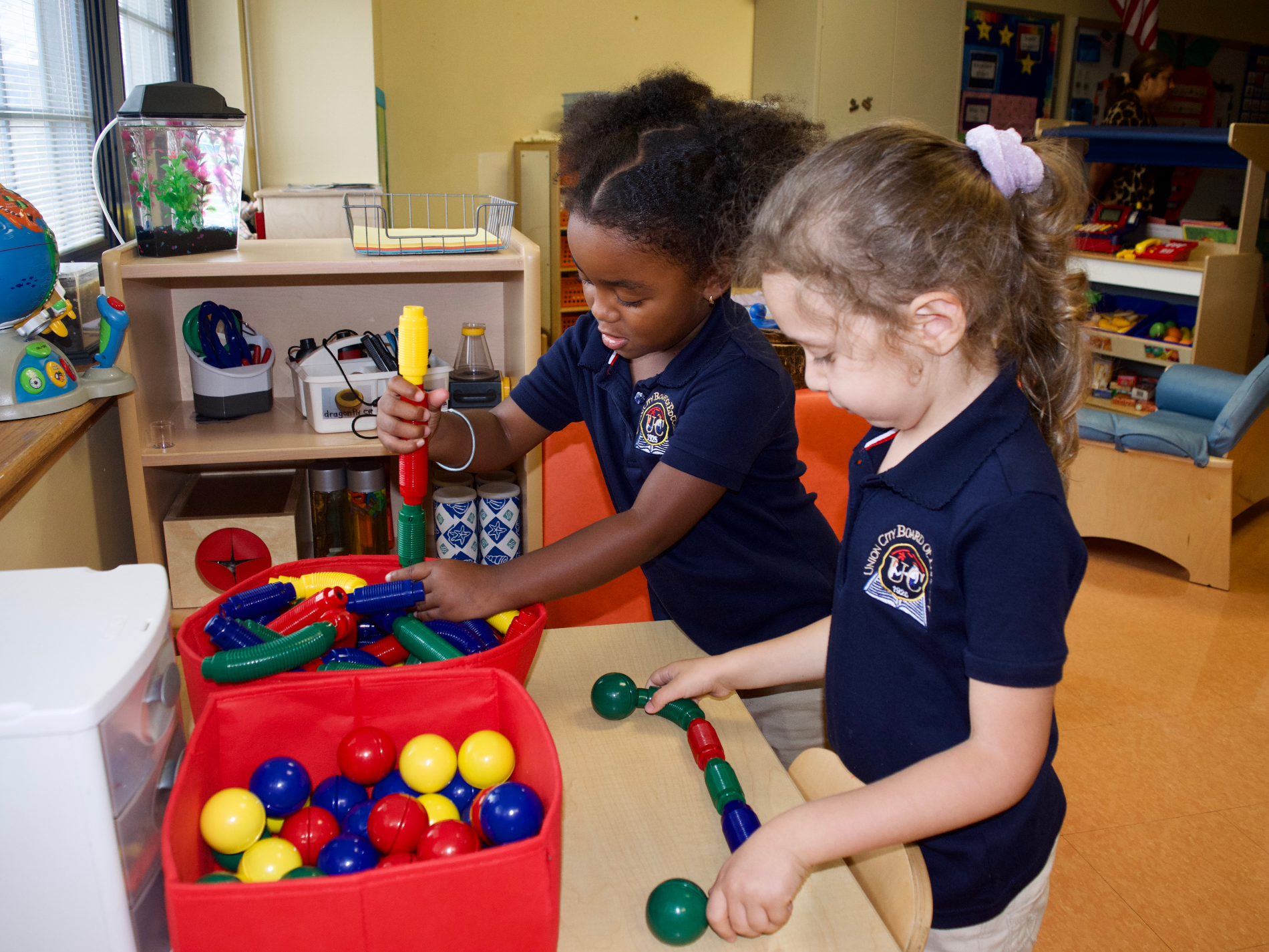 Two students in Melissa O’Dell’s preschool classroom play in the science center. Teachers at Union City often lead children through a song during transitions, to help them anticipate a change in activities. (Credit: Emily Tate)