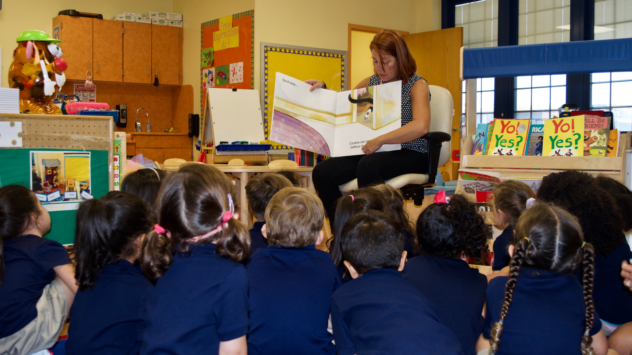 Lead teacher Melissa O'Dell reads "Cookie's Week" to children during morning story time. (Credit: Emily Tate)