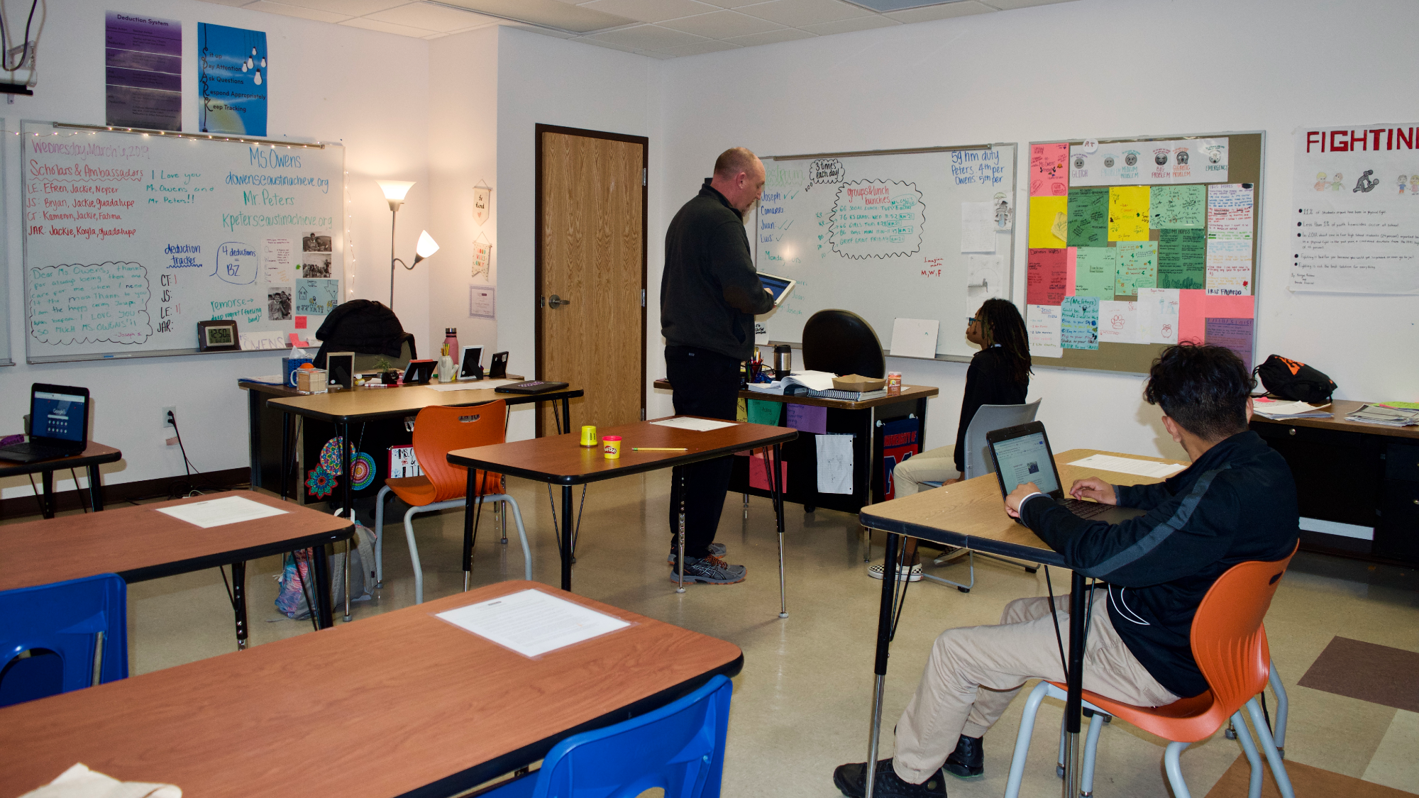 Above: The cool-down area of the RJ middle school classroom. Below: Kenn Peters, one of two full-time middle school RJ coordinators, speaks with a student in the RJ program. (Image credit: Alex Sigillo)
