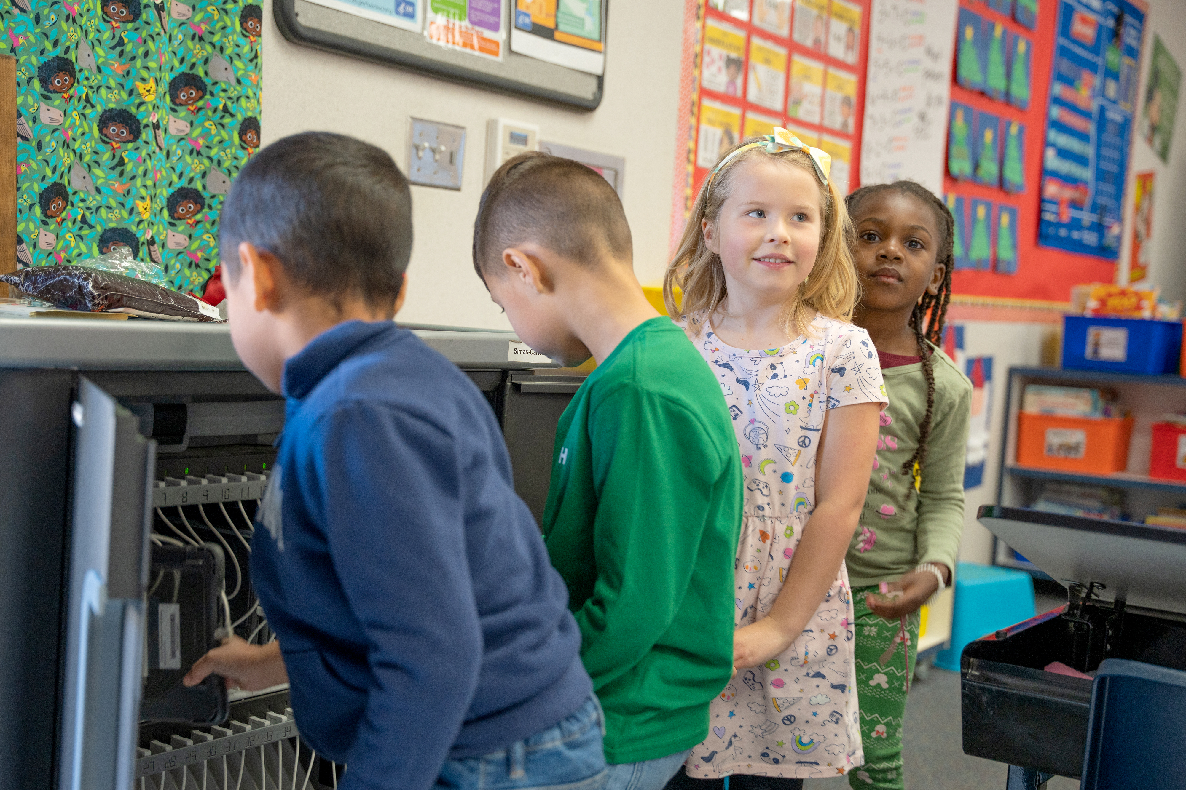 Young learners waiting in line for their devices