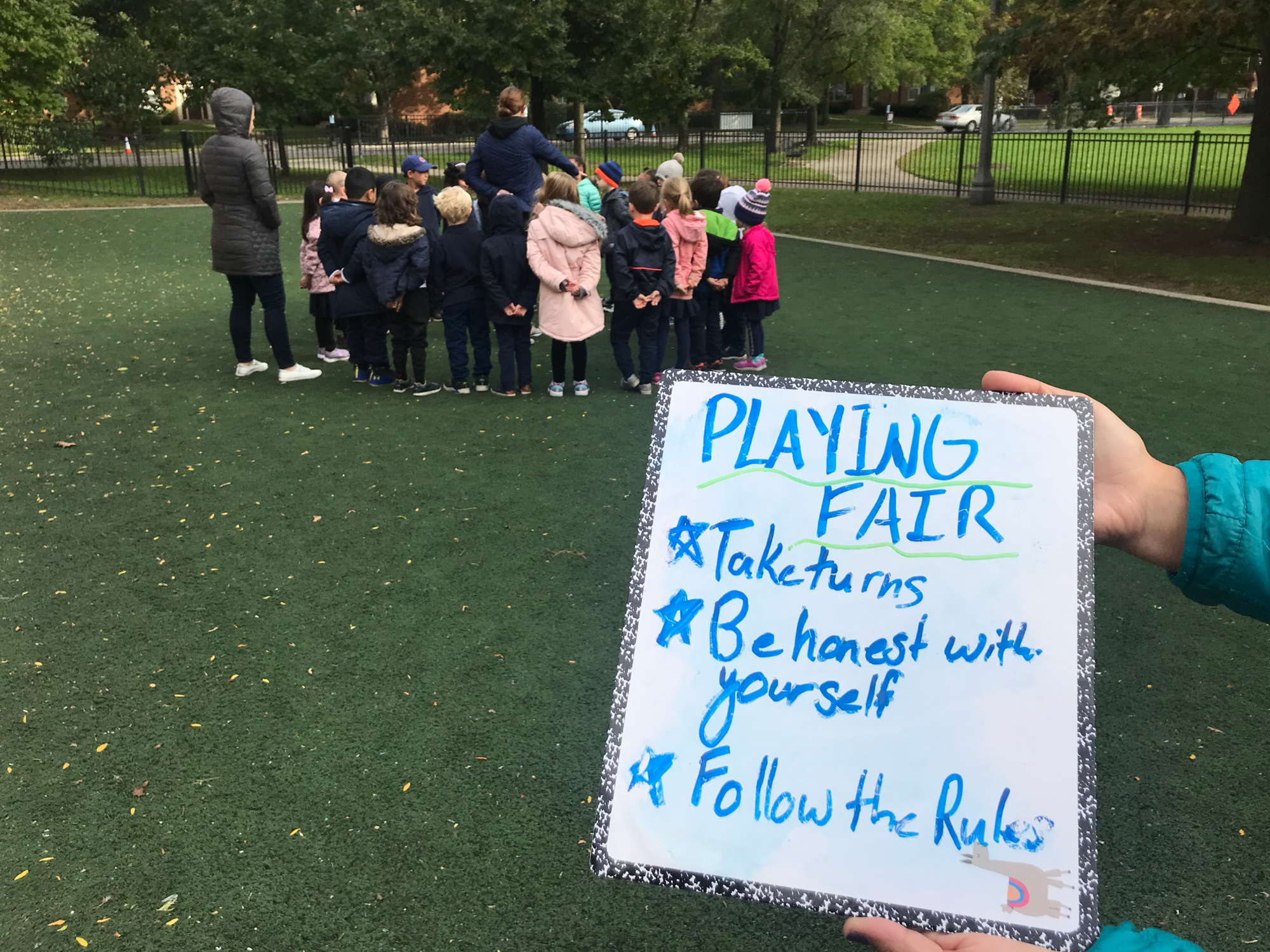 Playworks Coach Stephanie Ovitt leads kindergarteners through the rules of a new game. (Emily Tate / EdSurge)