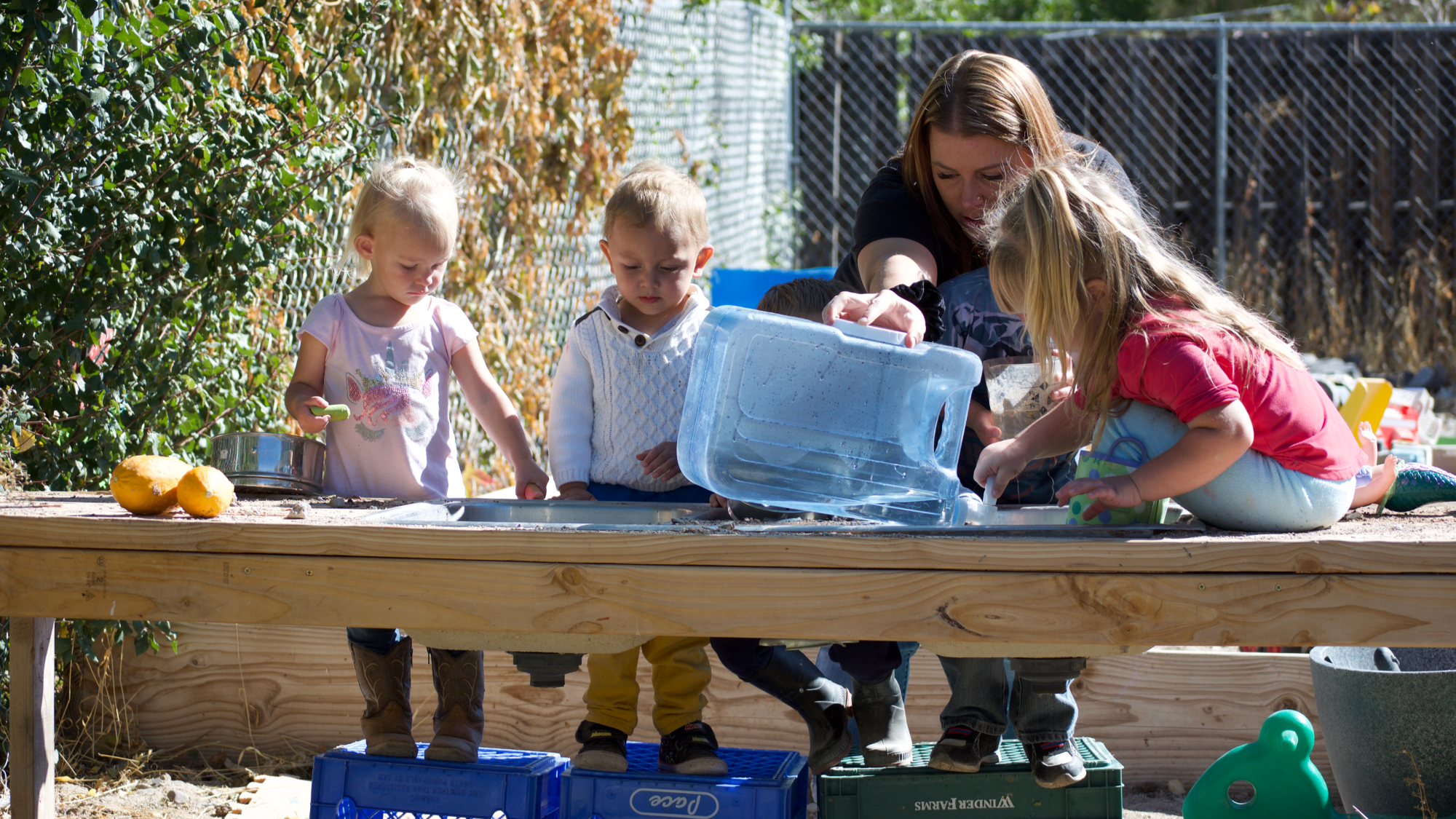 During outside play, Shotwell helps several of the children use sand and water to develop their sensory skills. (Emily Tate / EdSurge)
