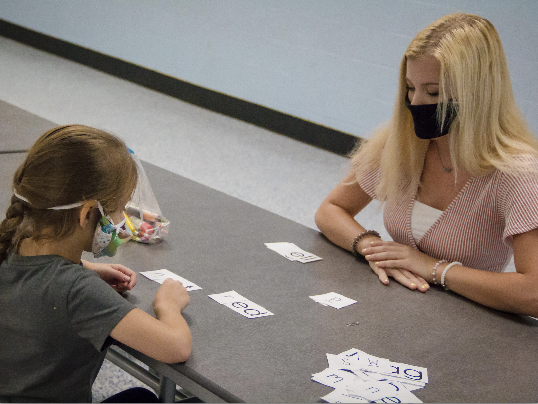 Mia, 6, plays a reading game with Lauren, a tutor for the Tennessee Tutoring Corps, by mixing and matching letters. (Credit: Michelle Lamont)