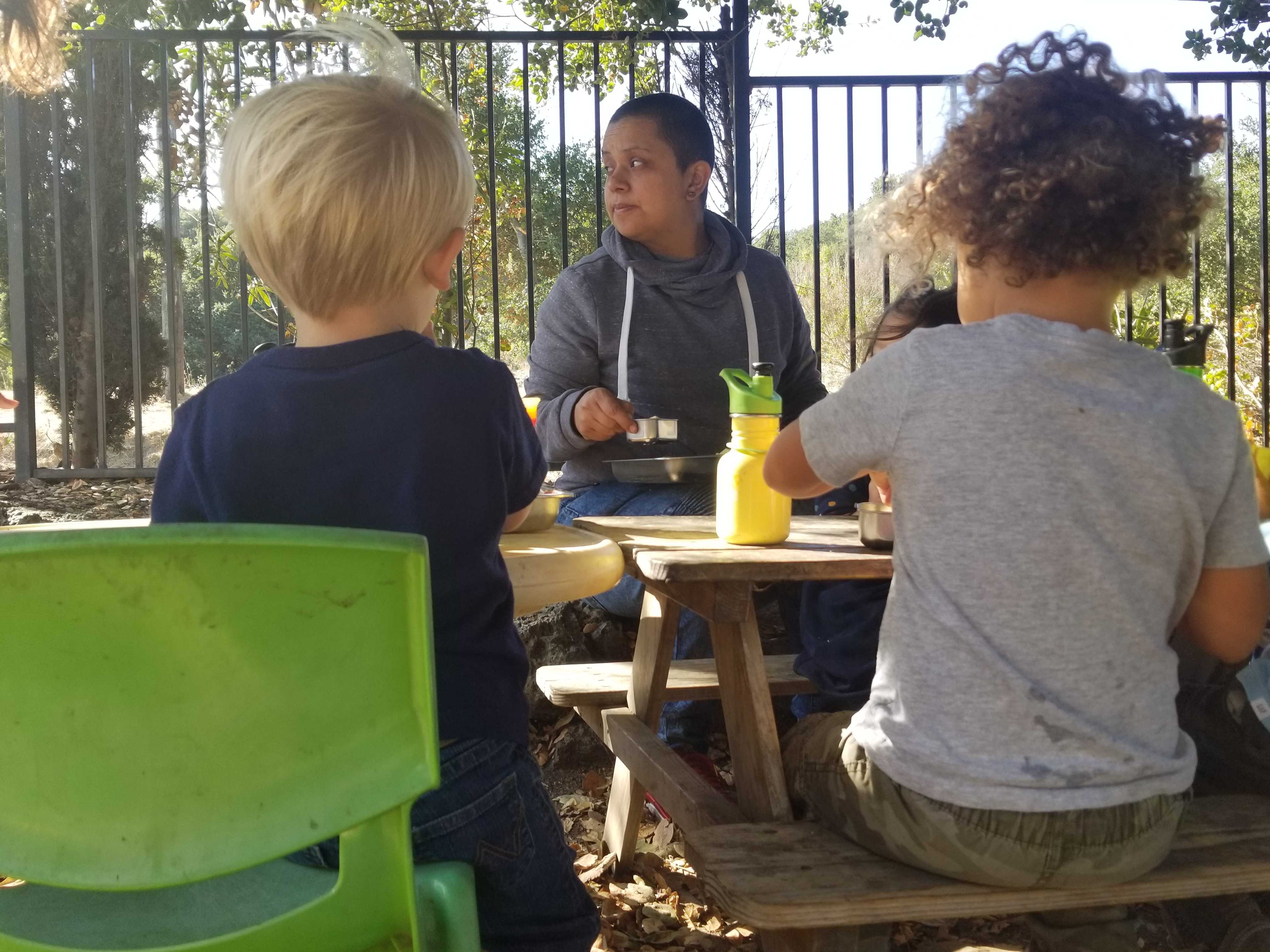 Cleo Escamilla, center, feeds Finn, left, and Kauê snacks at Bolden-Kramer’s home-based preschool in California. Credit: Wade Tyler Millward / EdSurge