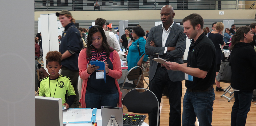 Morning keynote speaker, Henry Hipps (in white collar and suit), and others check out Pixel Press