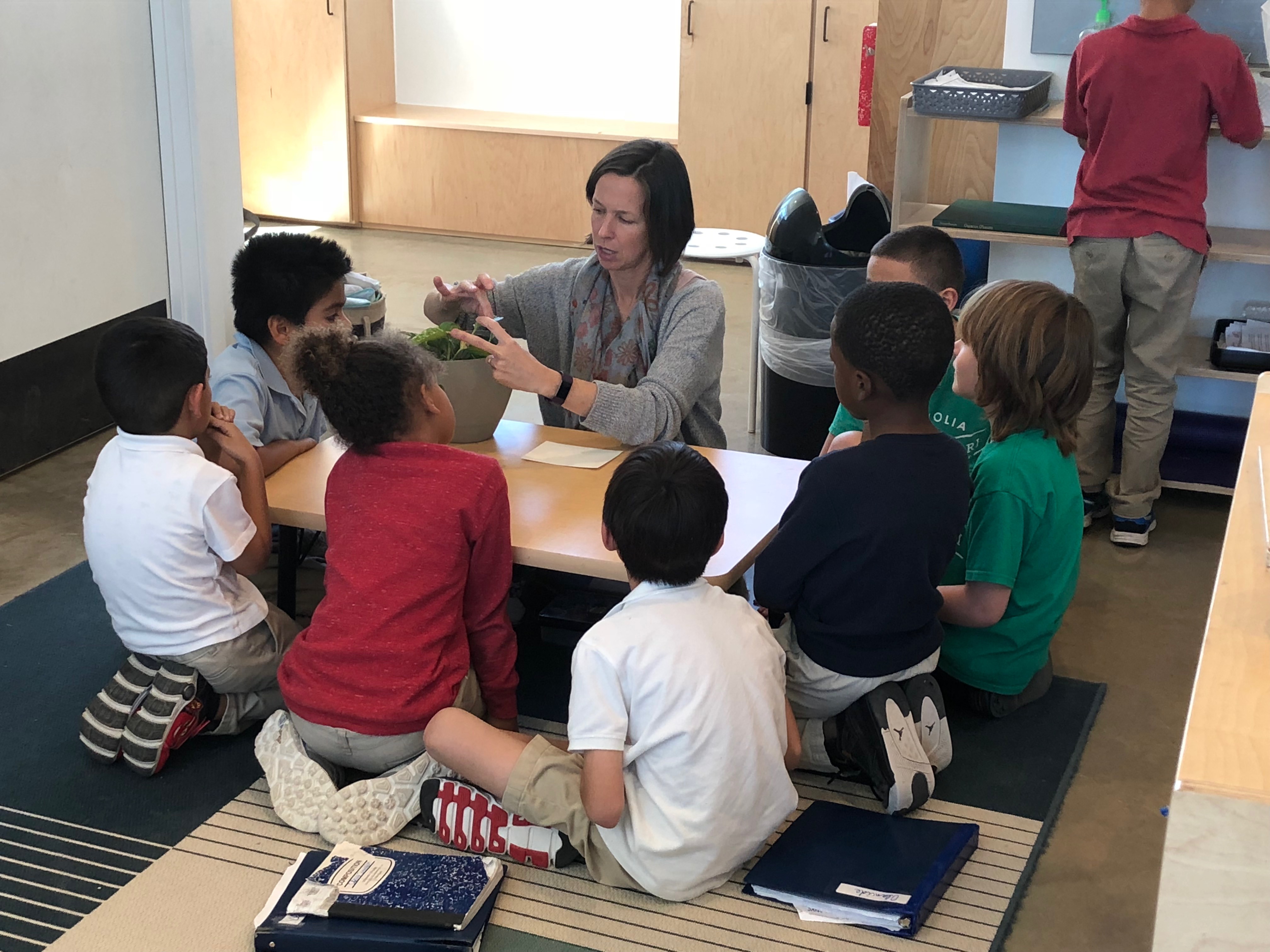 Guide (or teacher) talking to a group of students in a class. Photo Credit: Jenny Abamu