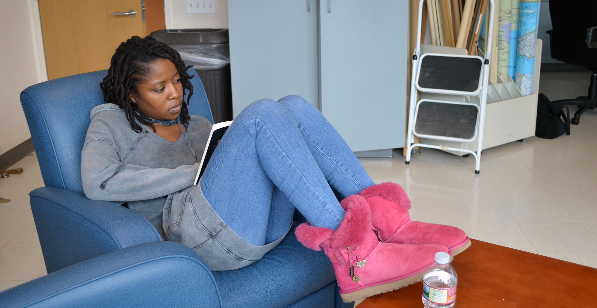 San Francisco State student Shati Ayinde-Passmore curls up on a chair reading “Notes From Underground.”