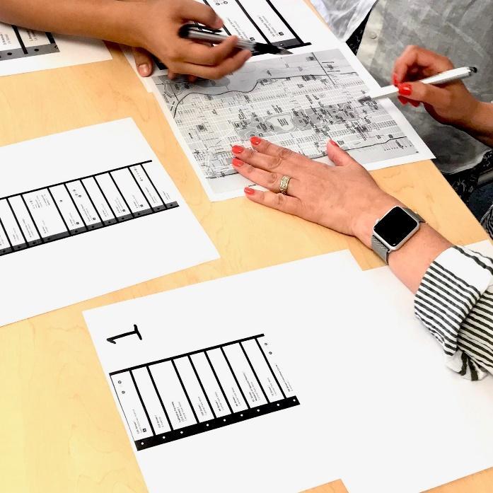 Teachers use subway maps to solve problems at a PD workshop.