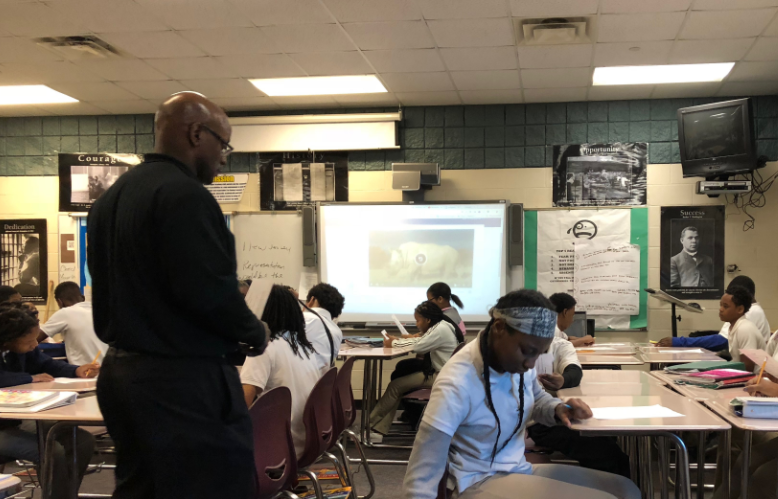Carl Brownlee walking aroud the classroom offering feedback to students. Photo Credit: Jenny Abamu