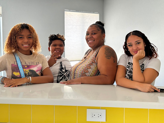 Destinee Hodges, center, inside her new home with her two children (left) and her goddaughter (right). Photo courtesy of Mission Driven Finance.