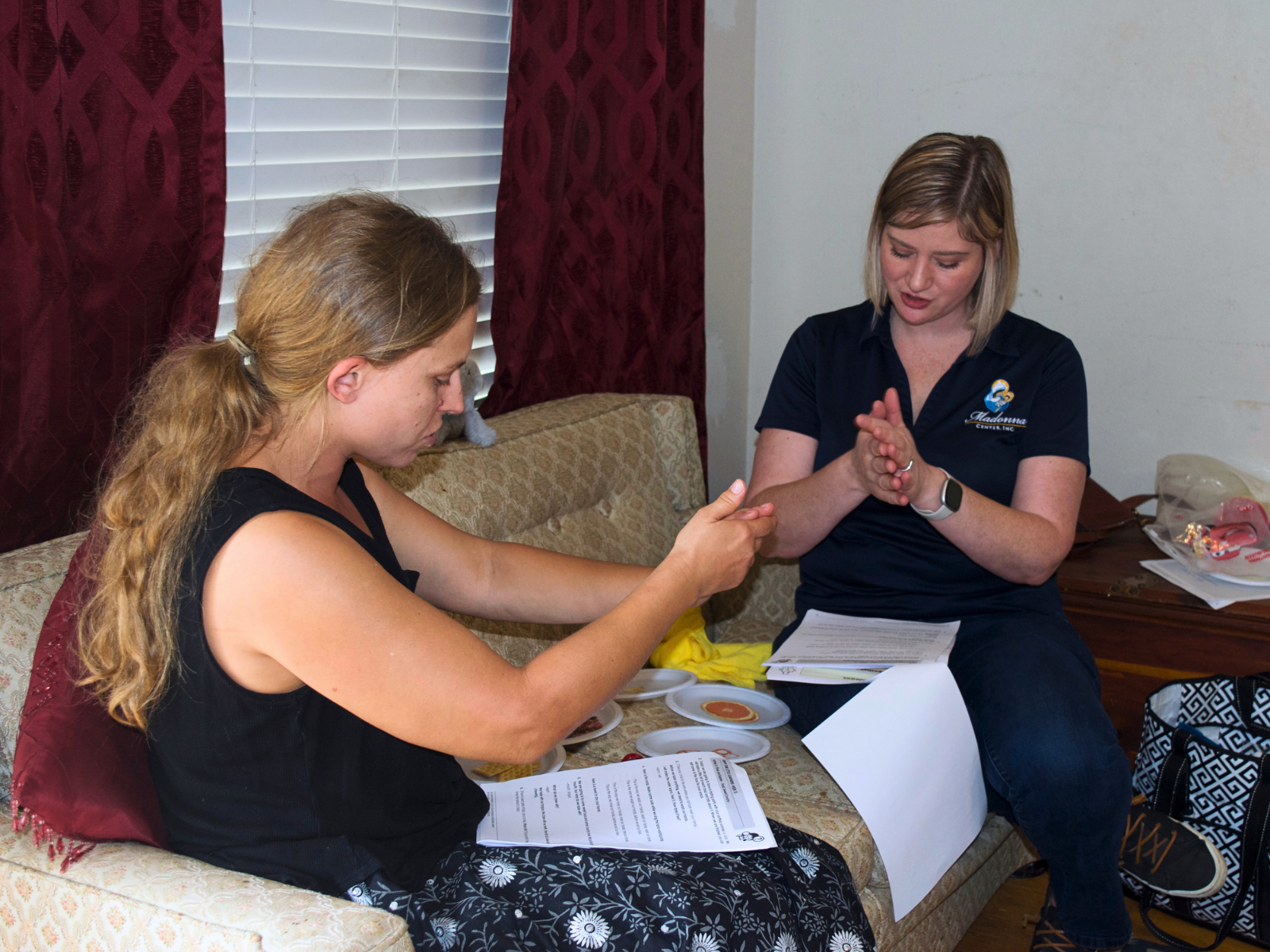 Bridget Collins, left, and home visitor Amanda Pedlar role-play washing their hands ahead of a "tasting party" where they will distinguish between sweet and crunchy foods. Photo by Emily Tate Sullivan.