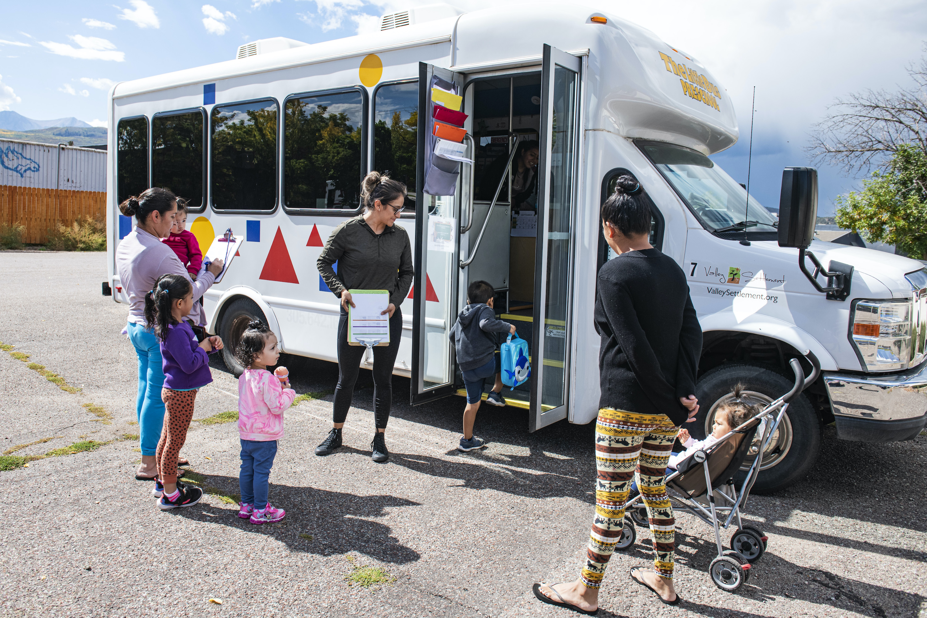Lead teacher Sarai Ramirez, center, checks students in to El Busesito. Photo by Kelsey Brunner for EdSurge.