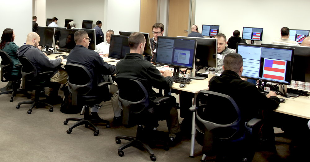 Students engaged with an Acuitus training program that combines computer-based learning with human mentors to compress 10 years of experience and learning into 5 months. (Photo source: Acuitus)
