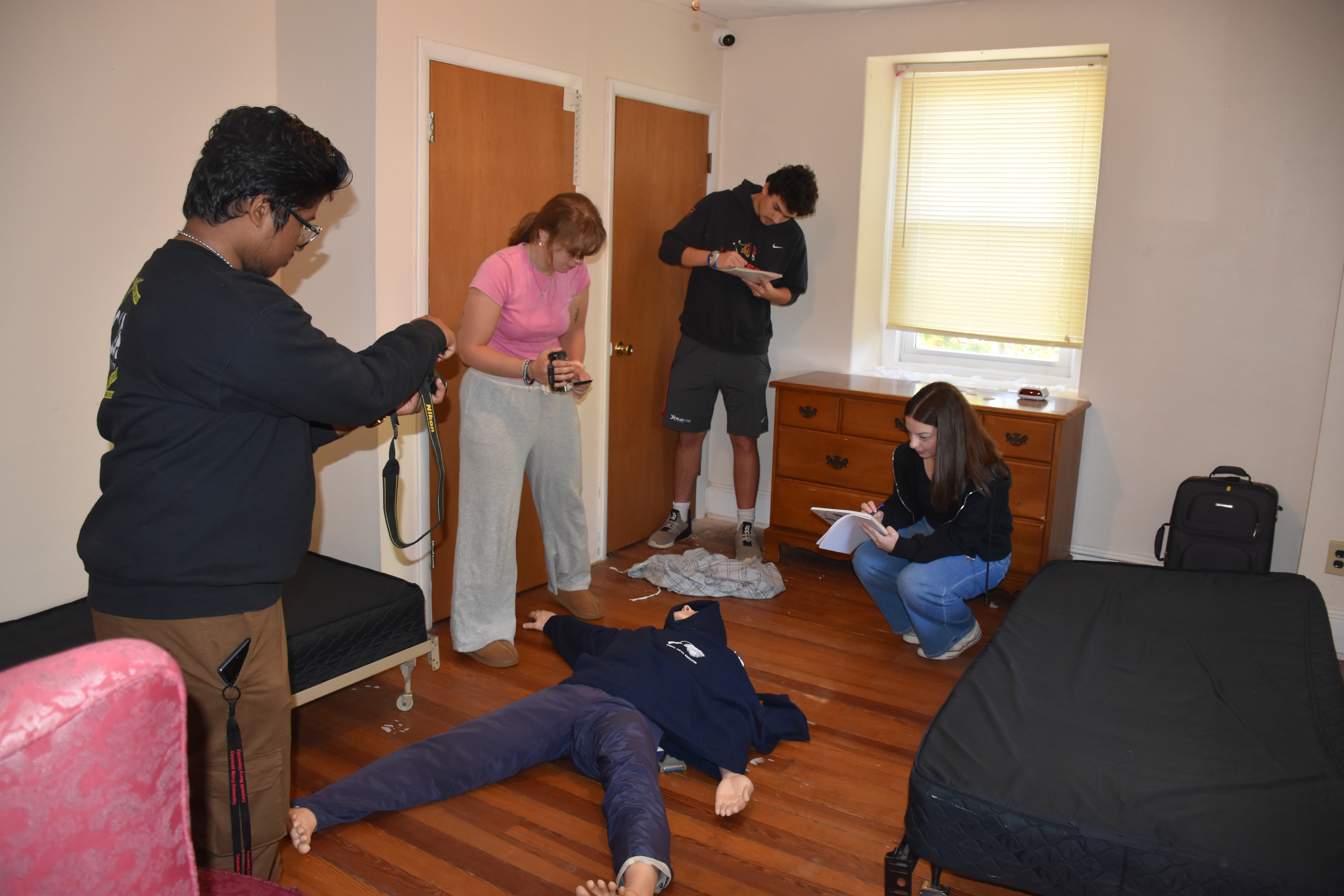Criminal justice students at Gwynedd Mercy University examine a case set up in the school's Crime Scene House. Photo courtesy of Gwynedd Mercy University.