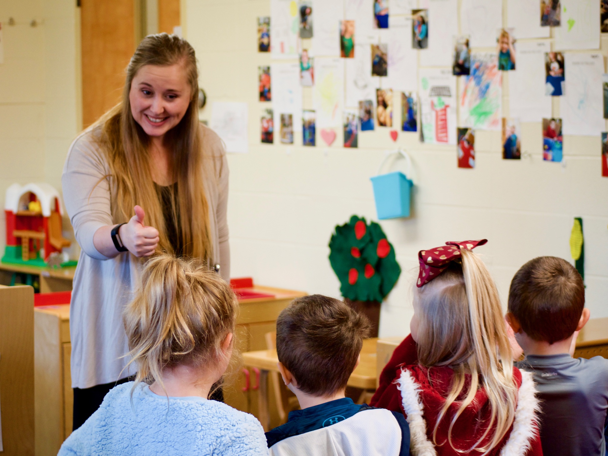 Ashley Dobrozsi-Ferguson, director of the TIP program, helps children in Classroom B line up. (Emily Tate / EdSurge)