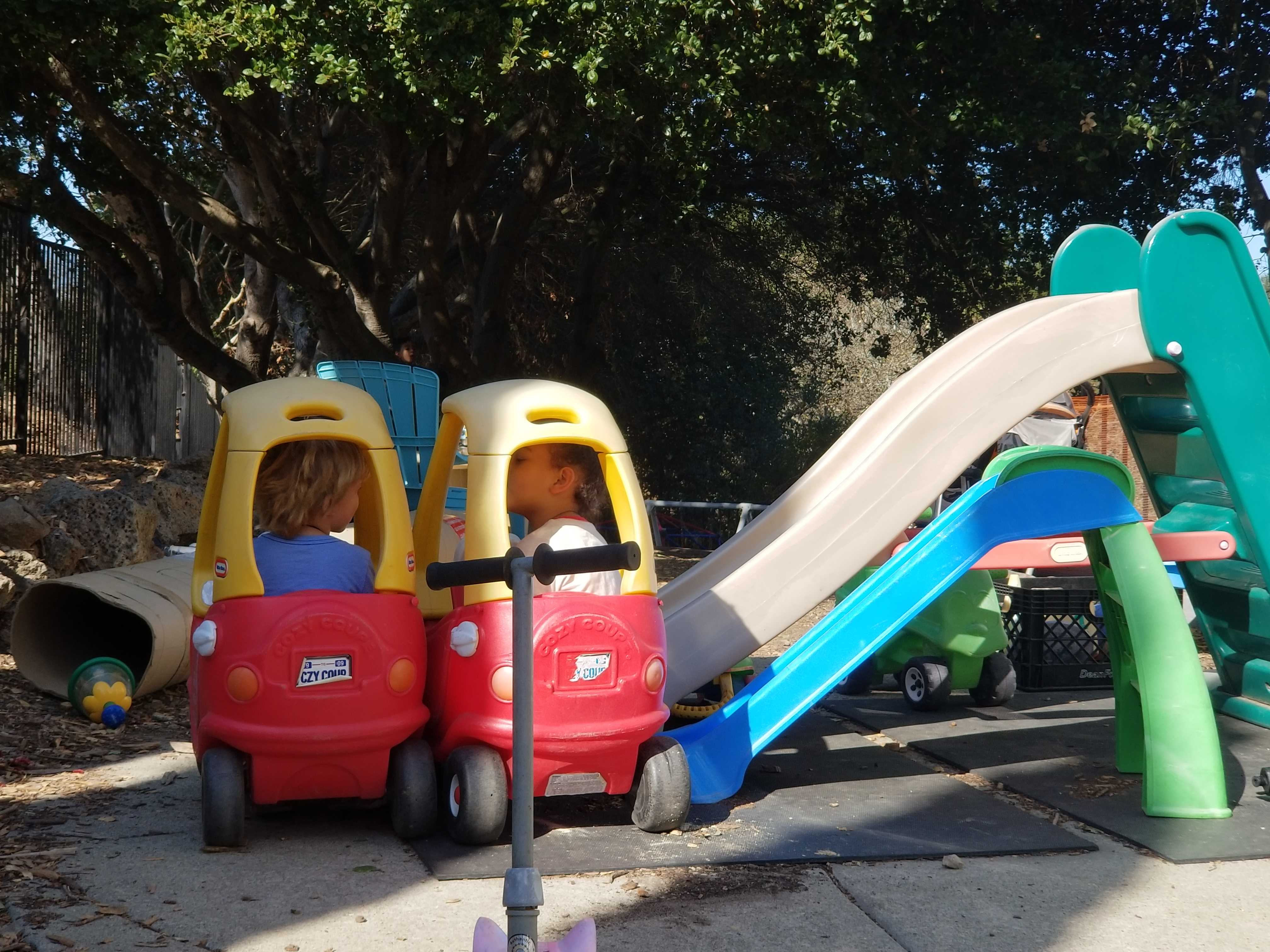 Isaac, left, and Caden, two children enrolled in Rachel Bolden-Kramer’s home-based preschool in California, talk in a makeshift playground outside Bolden-Kramer’s house. Credit: Wade Tyler Millward / EdSurge