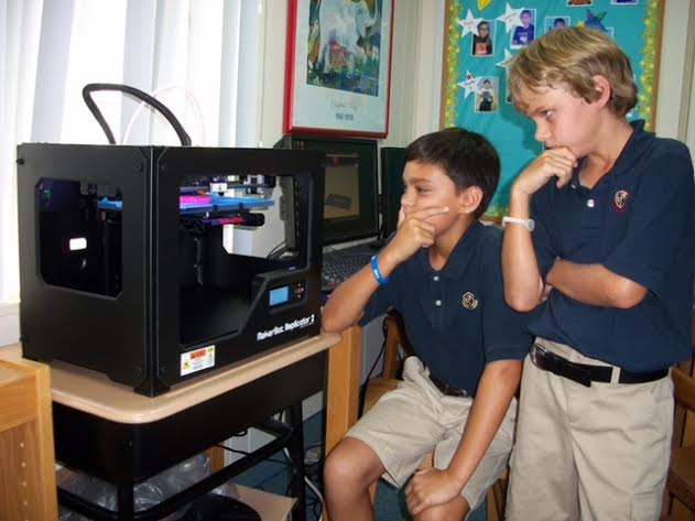 Students contemplate a 3D printer. (Judy Houser)