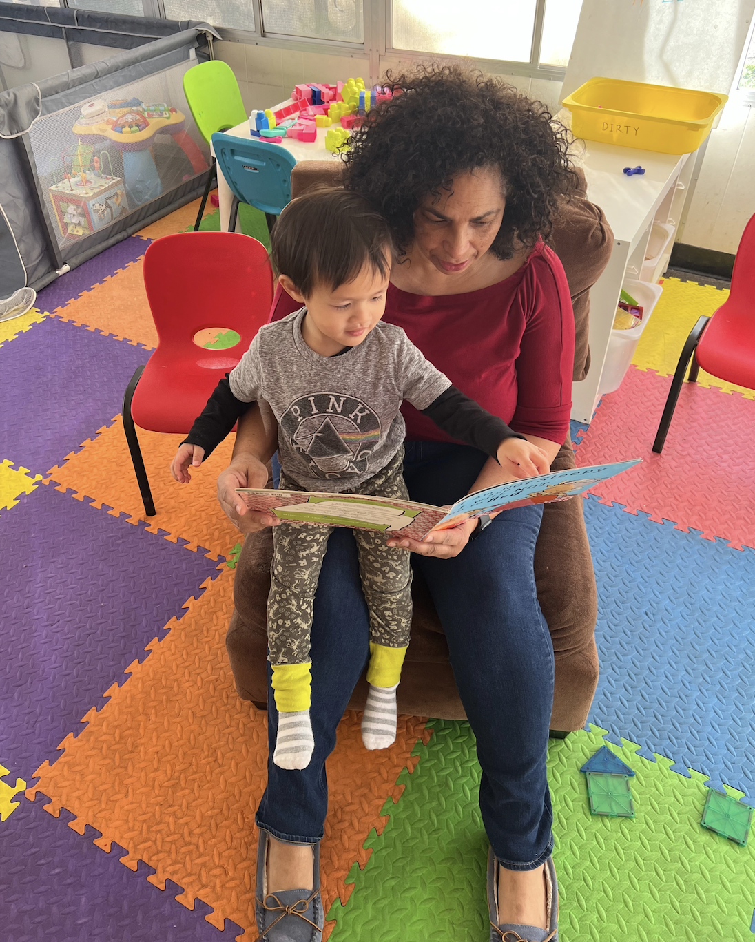 Hayley Wise, a home-based child care provider in San Mateo, California, reading to one of the children in her program. Photo courtesy of Wise.
