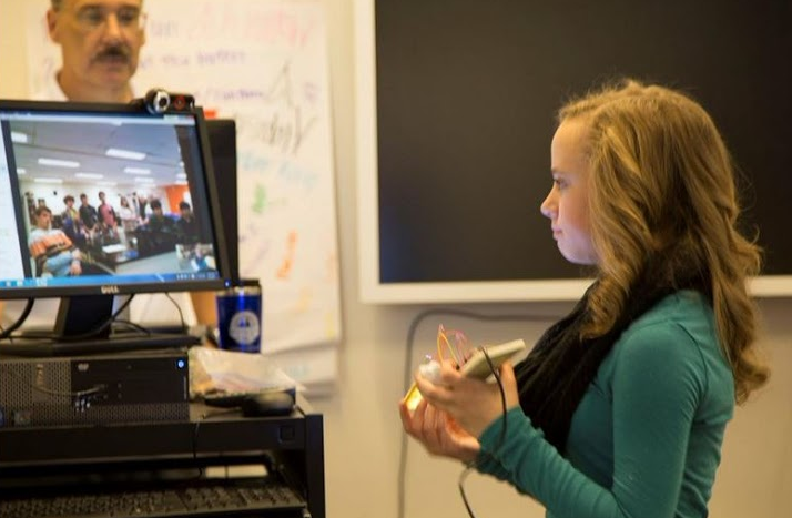 A student demonstrates a design idea to friends over Skype.
