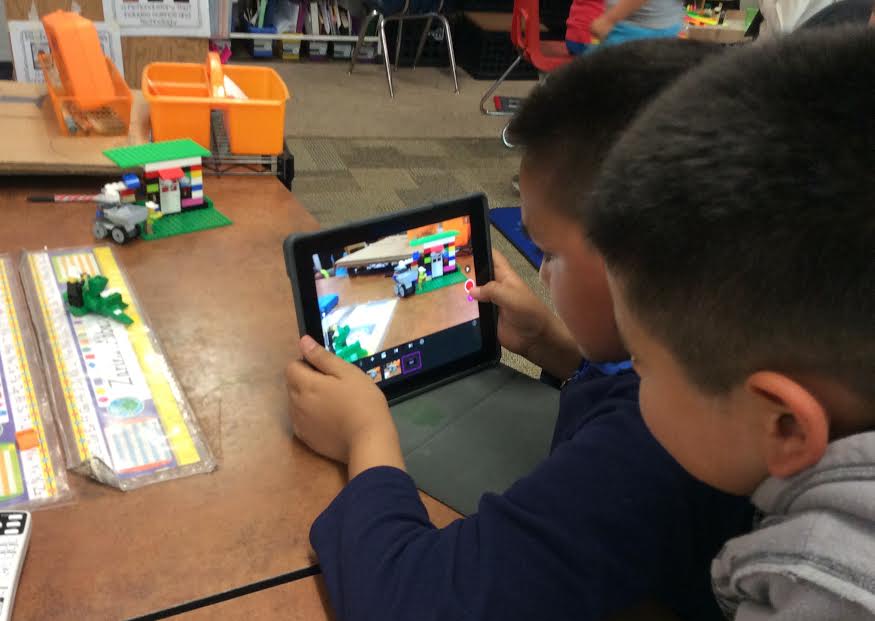 Older students show younger students how to create on an iPad. (Laura Busch)