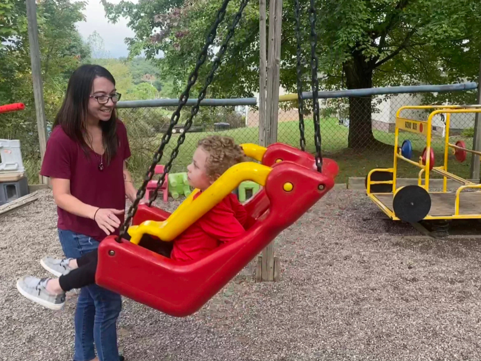 A teacher at A Place to Grow Children's Center pushes a child in a swing. Photo courtesy of A Place to Grow Children's Center.