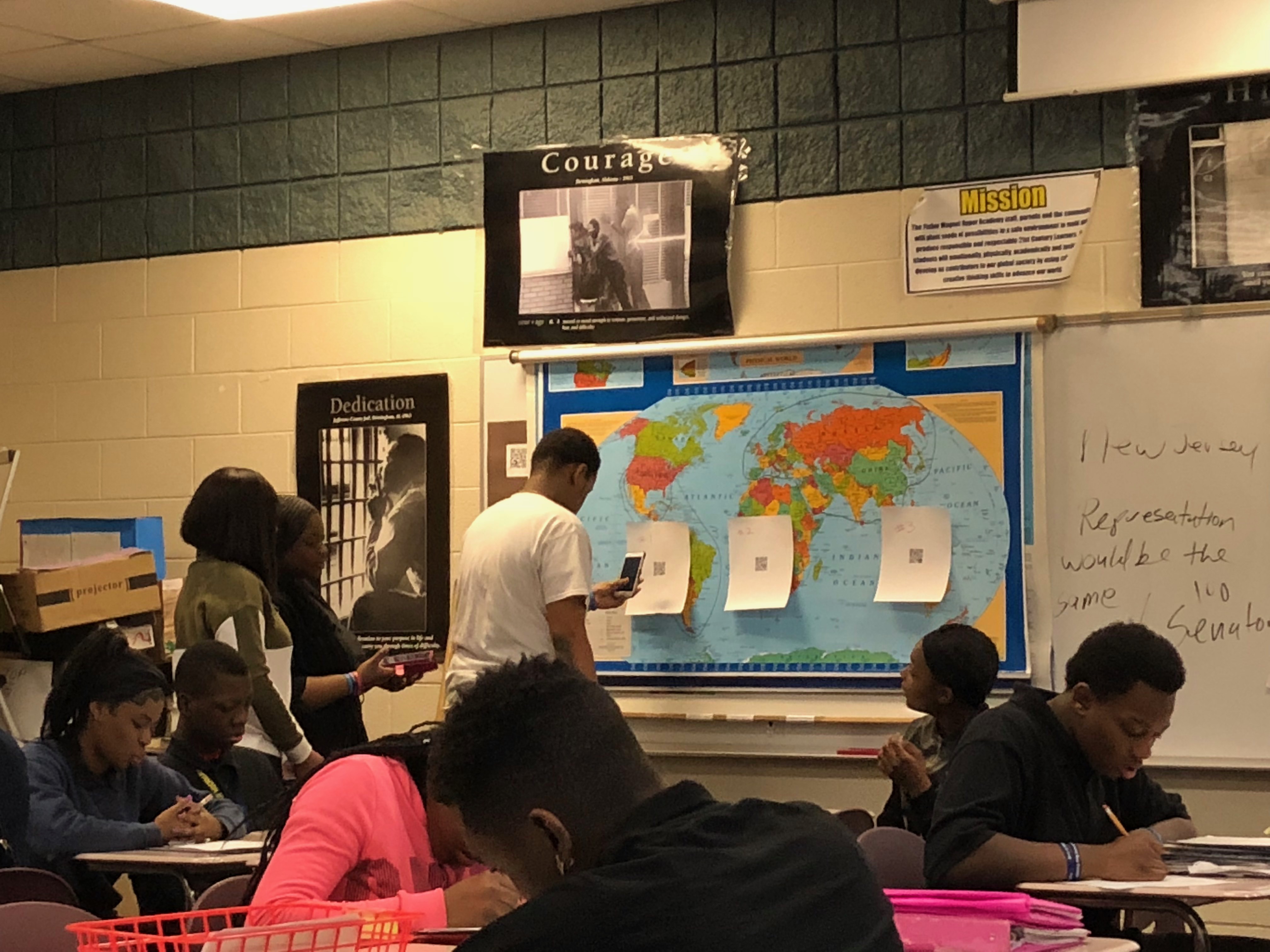 Students using cell phones to scan QR Codes during station work in Brownlee's classroom. Photo Credit: Jenny Abamu
