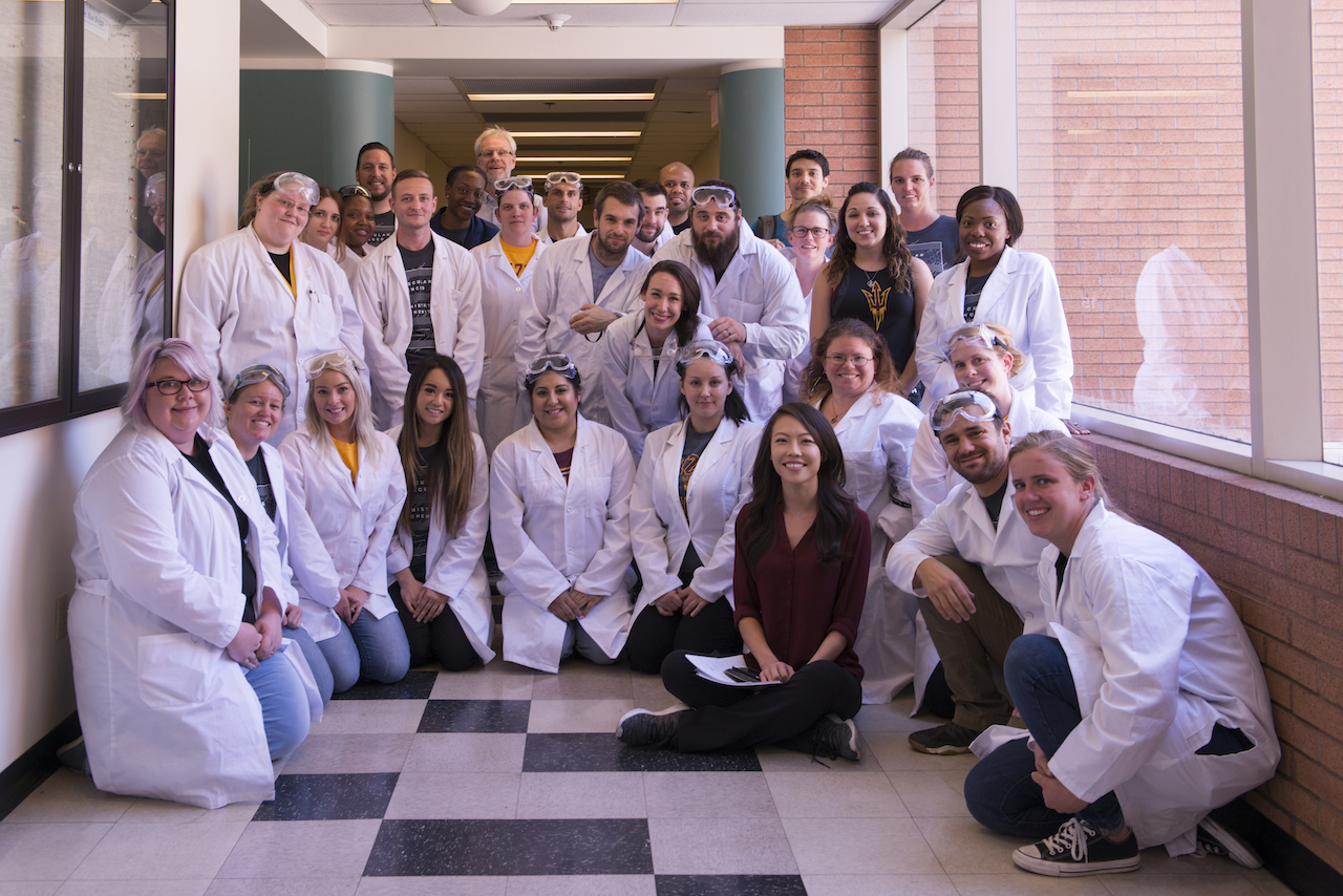 Ara Austin (seated) surrounded by ASU students in lab coats. Photo courtesy of Arizona State University.