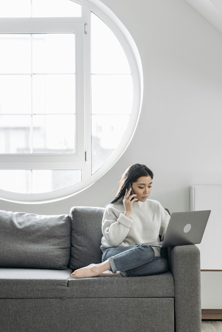Woman on couch using a laptop