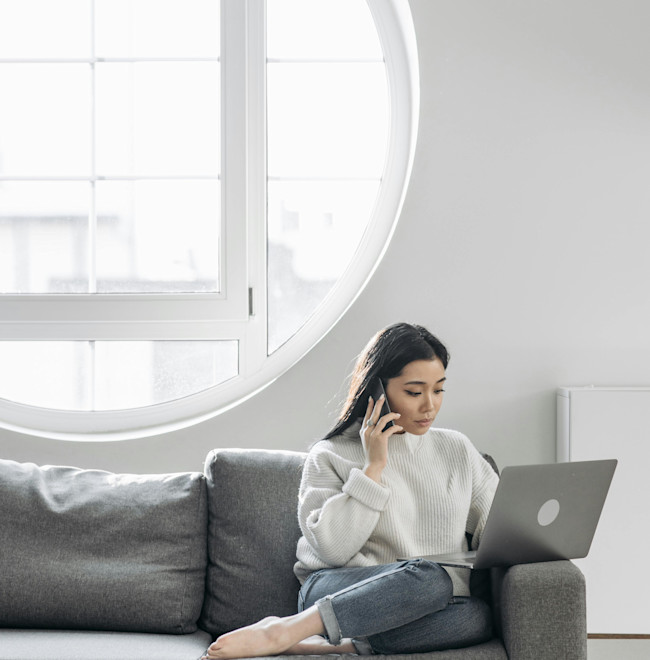 Woman on couch using a laptop