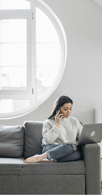 Woman sitting on couch using a laptop