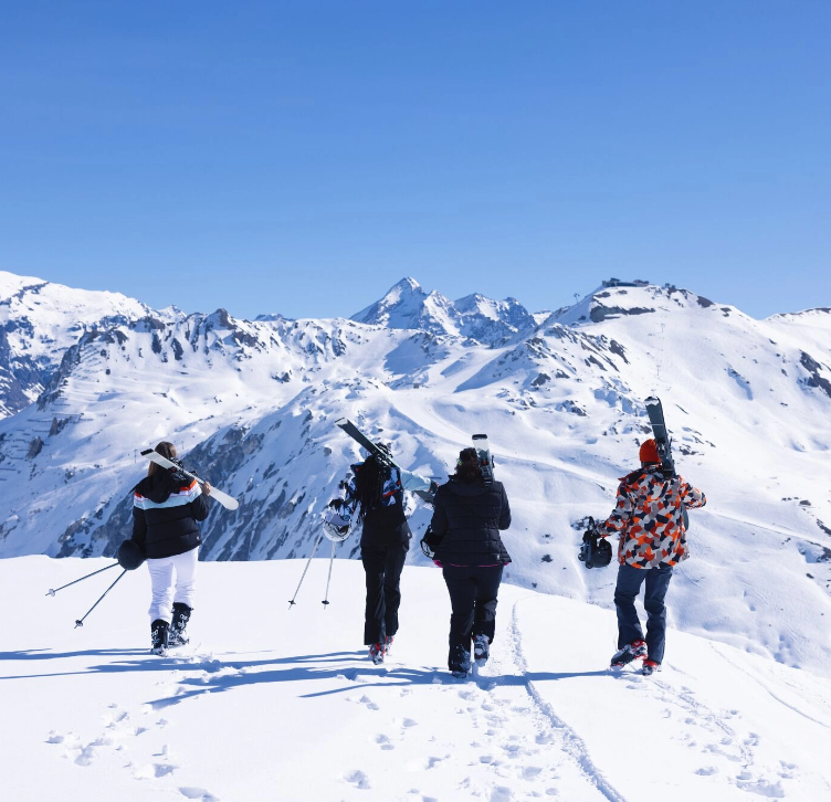 Leute gehen mit ihren Skiern in die Berge