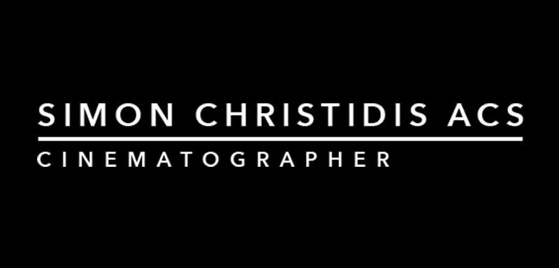 White text on a black background reads "Simon Christidis ACS" above a horizontal line, with the word "Cinematographer" below the line in all capital letters.