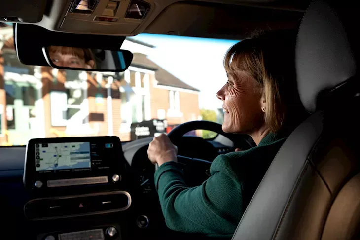 An image of a woman driving an electric vehicle 