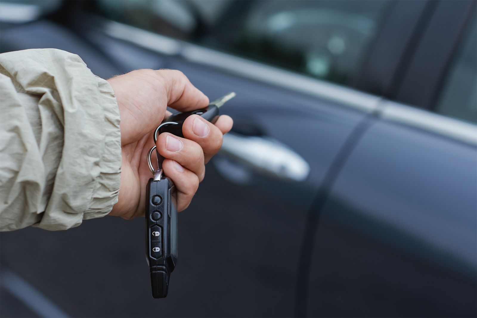 A person using a key fob to unlock their car