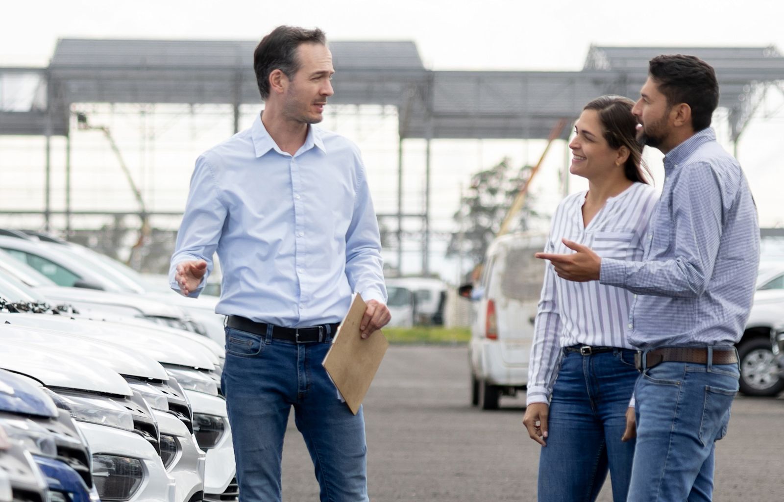 Couple at a Car dealership discussing cars with the employee