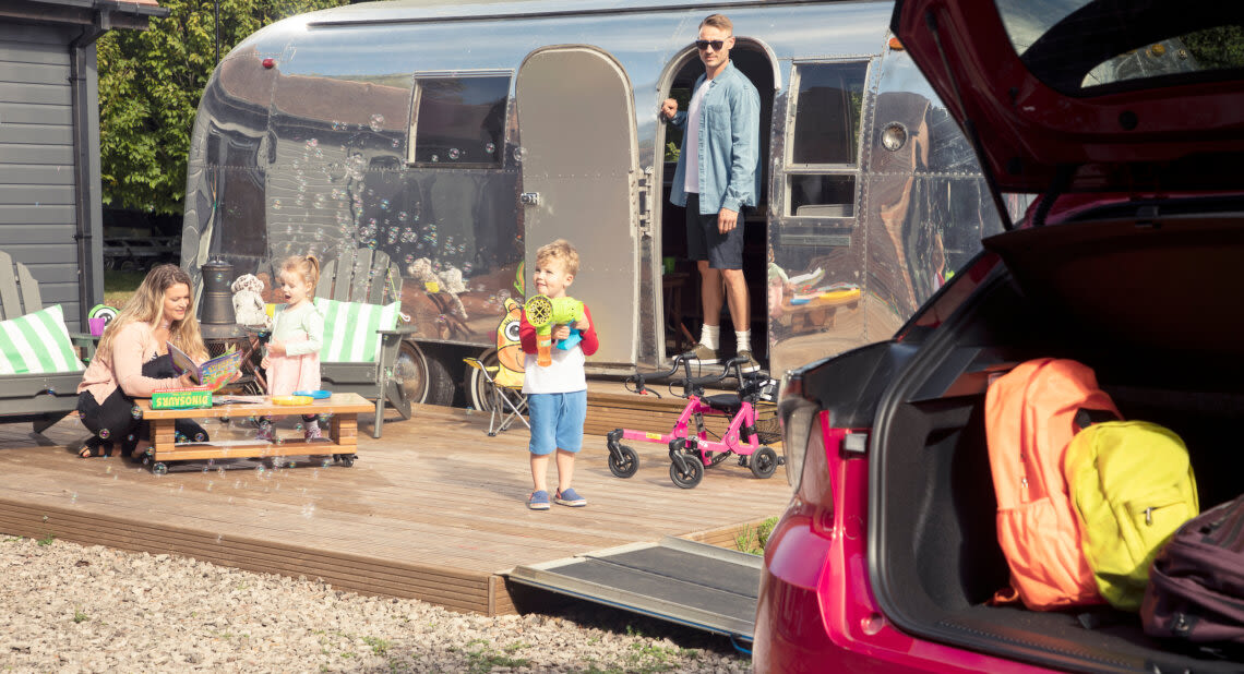 Family on holiday with their electric car unpacking