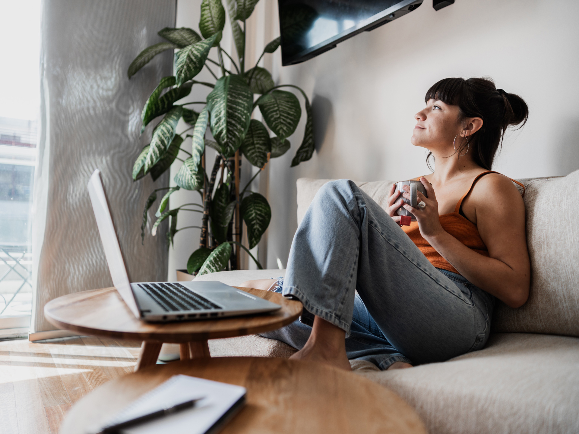 A person sitting on a sofa using a laptop