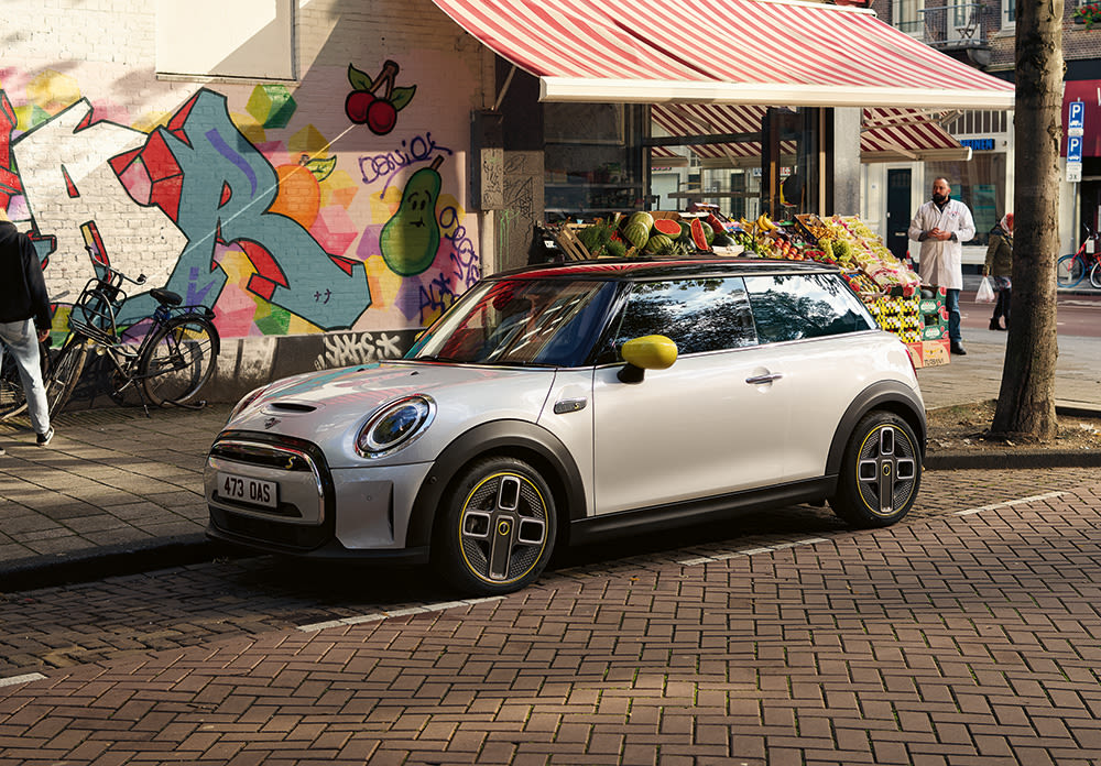 MINI car in white silver with black roof and yellow wing mirror