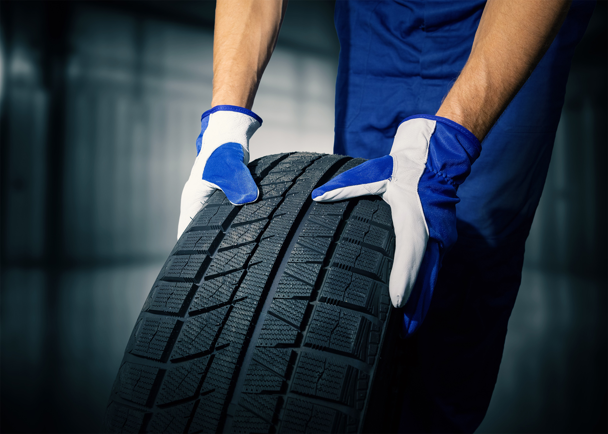 A person moving a car tyre