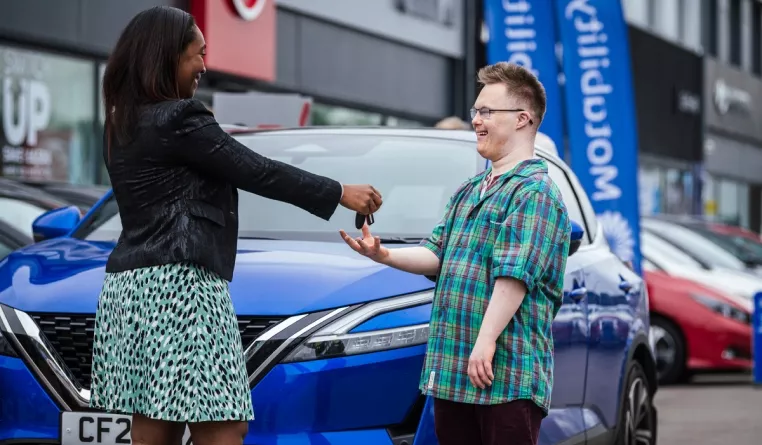man collecting his car keys from employee at car dealership