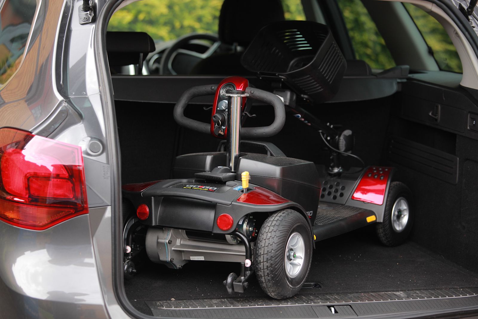 A mobility scooter folded inside a car boot