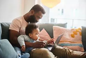 man and a child browsing on a laptop