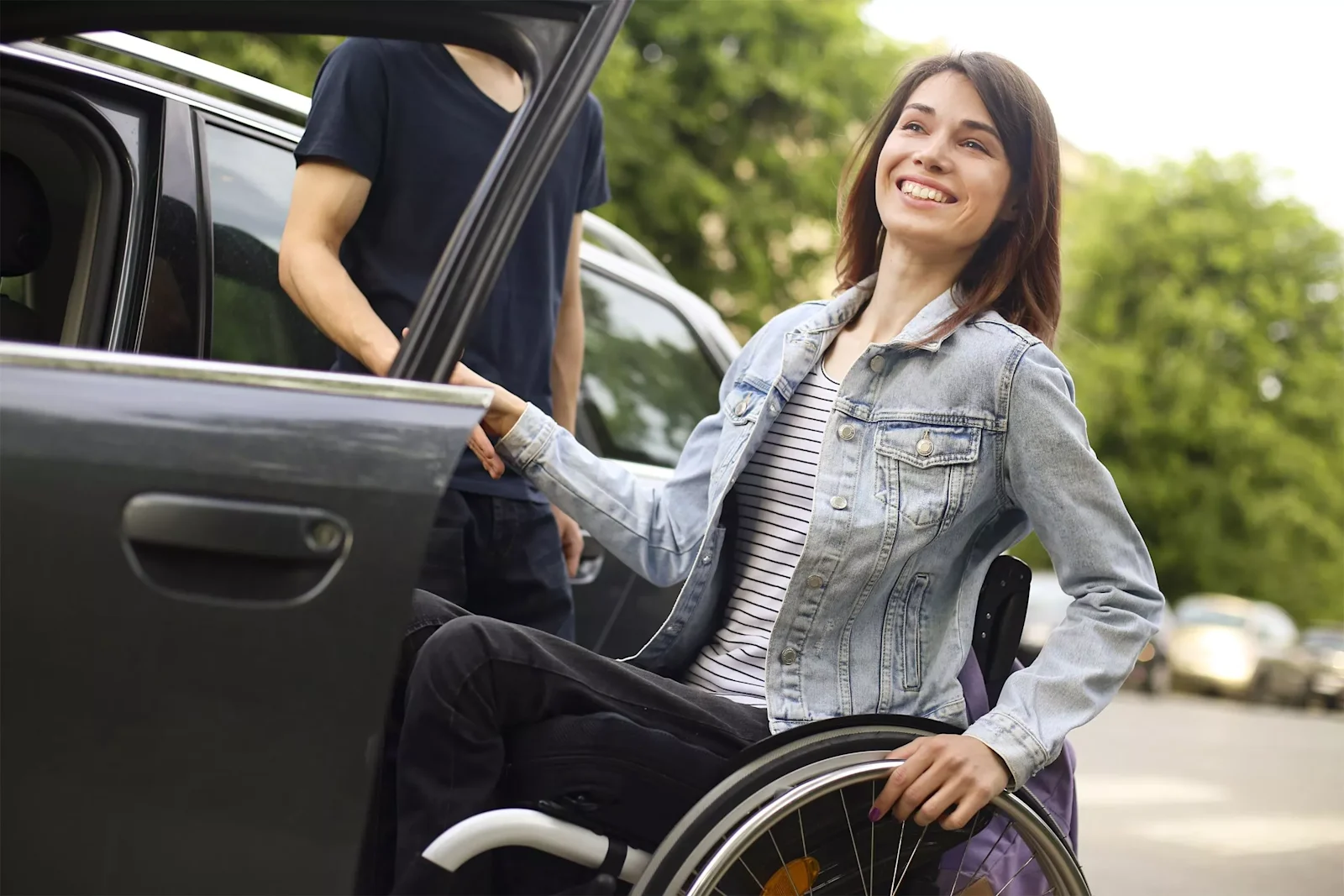 Woman in a wheelchair getting in a car